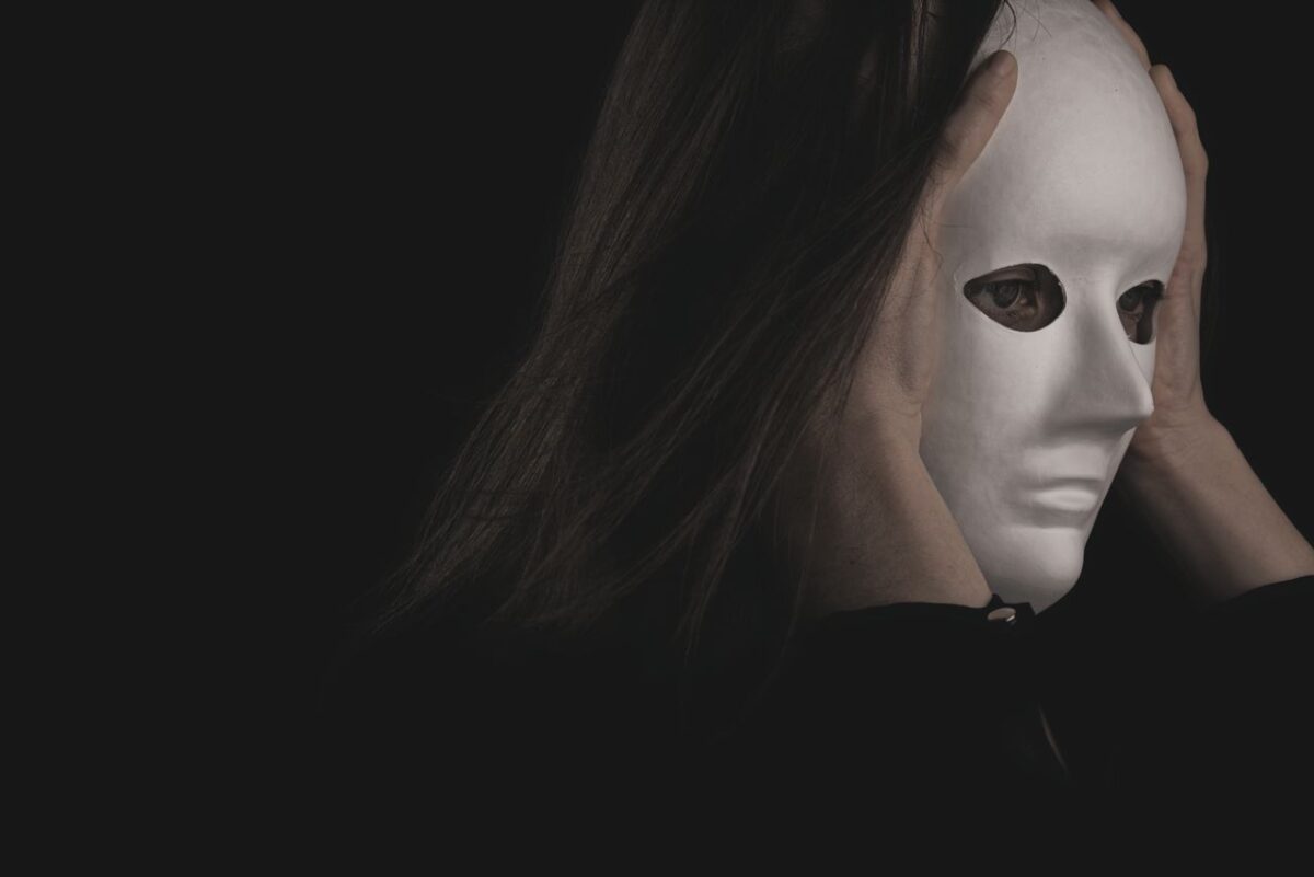 a-person-in-black-long-sleeve-shirt-wearing-a-white-mask-
