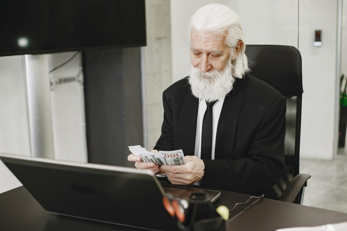 elderly-man-counting-money-in-office