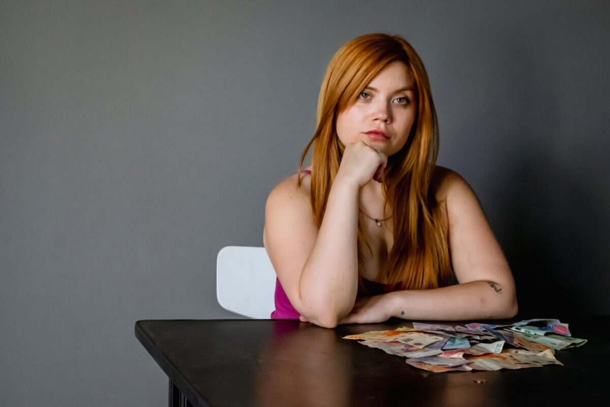 /thoughtful-woman-with-currency-at-table-