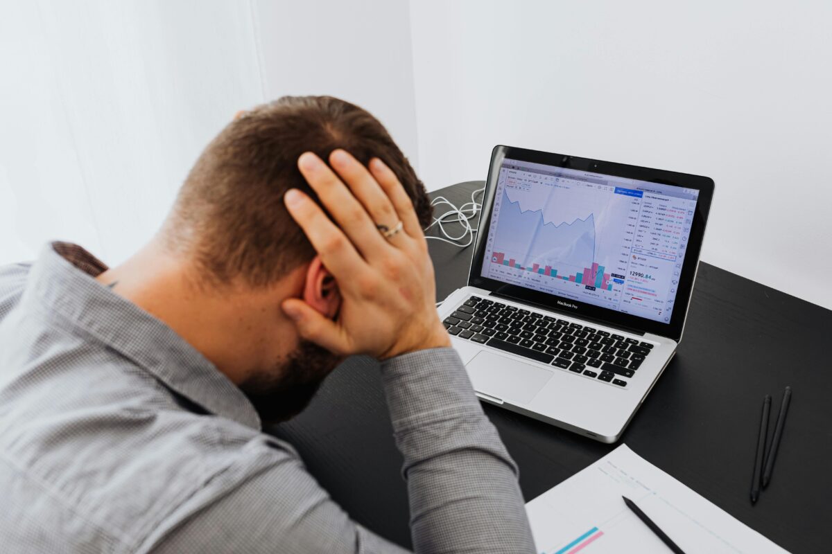 8 Childhood Money Habits That Are Suppressing Your Finances Today 5 man-with-laptop-on-desk-terrified-by-stock-market-chart
