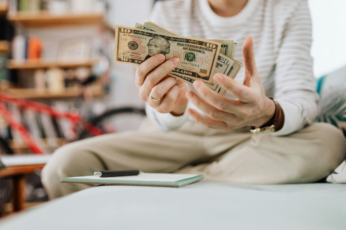 man-sitting-on-sofa-and-holding-money