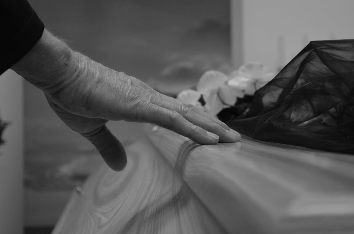 grayscale-photo-of-person-holding-a-coffin-