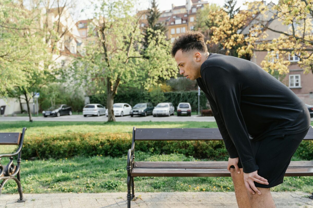 6 Symptoms You Should Never Dismiss as Normal Aging 3 Man in black sportswear resting on park bench after exercise session.