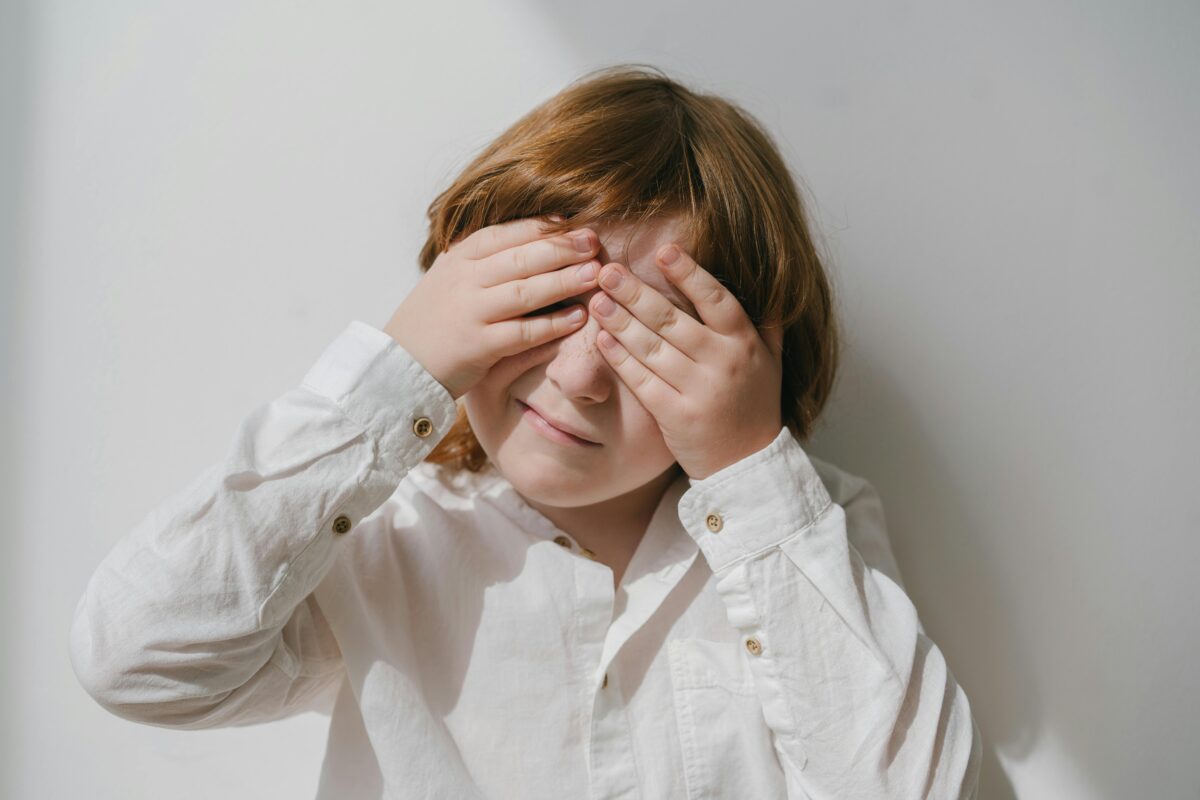 photograph-of-a-boy-covering-his-eyes