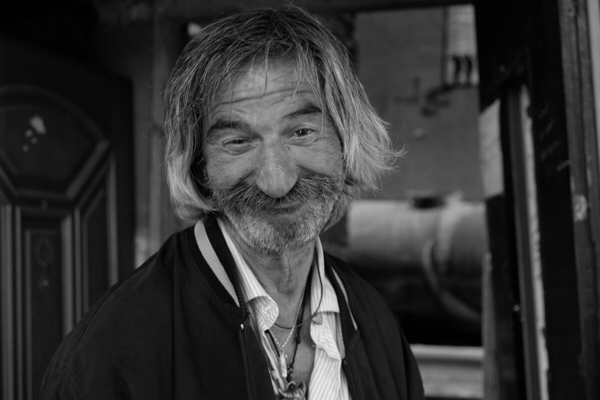 a-grayscale-of-a-bearded-man-smiling
