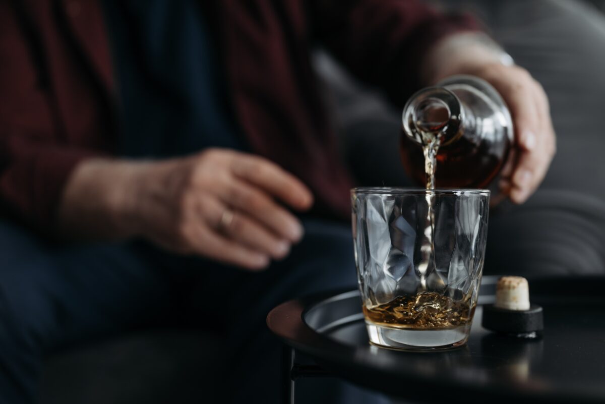 a-person-poring-liquor-in-a-glass