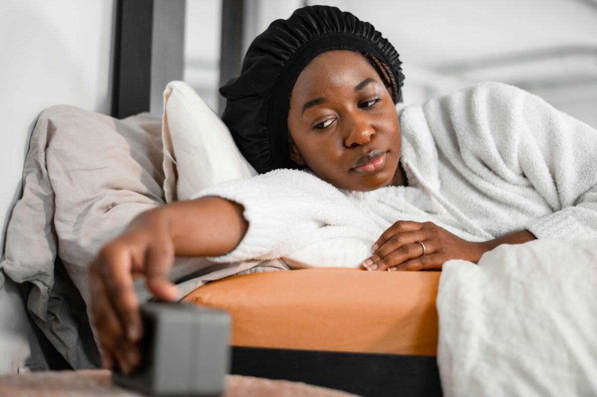 woman-in-bed-switching-alarm-clock-off