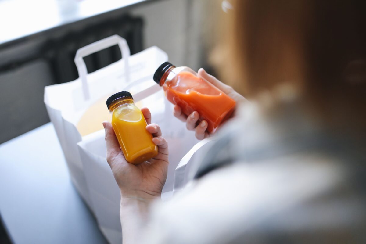 a-person-holding-bottles-of-juices