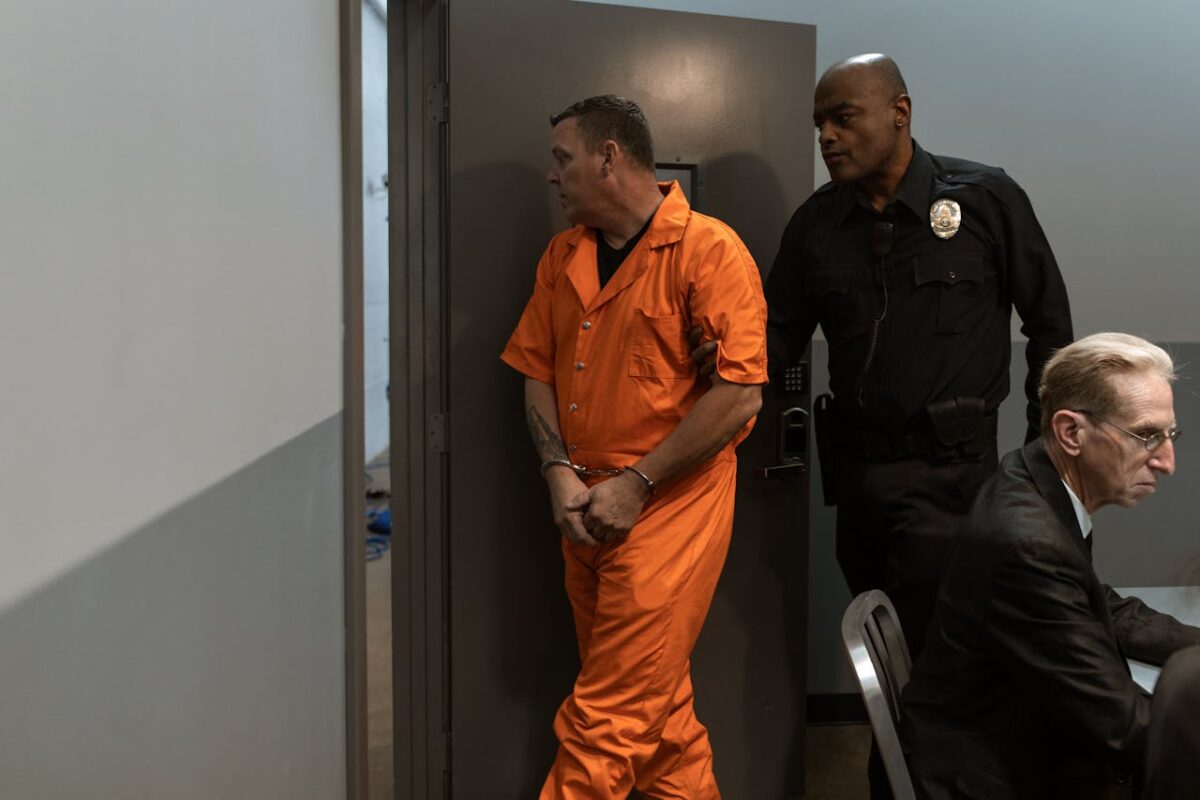 a-correctional-officer-escorting-a-prisoner-out-of-a-room-