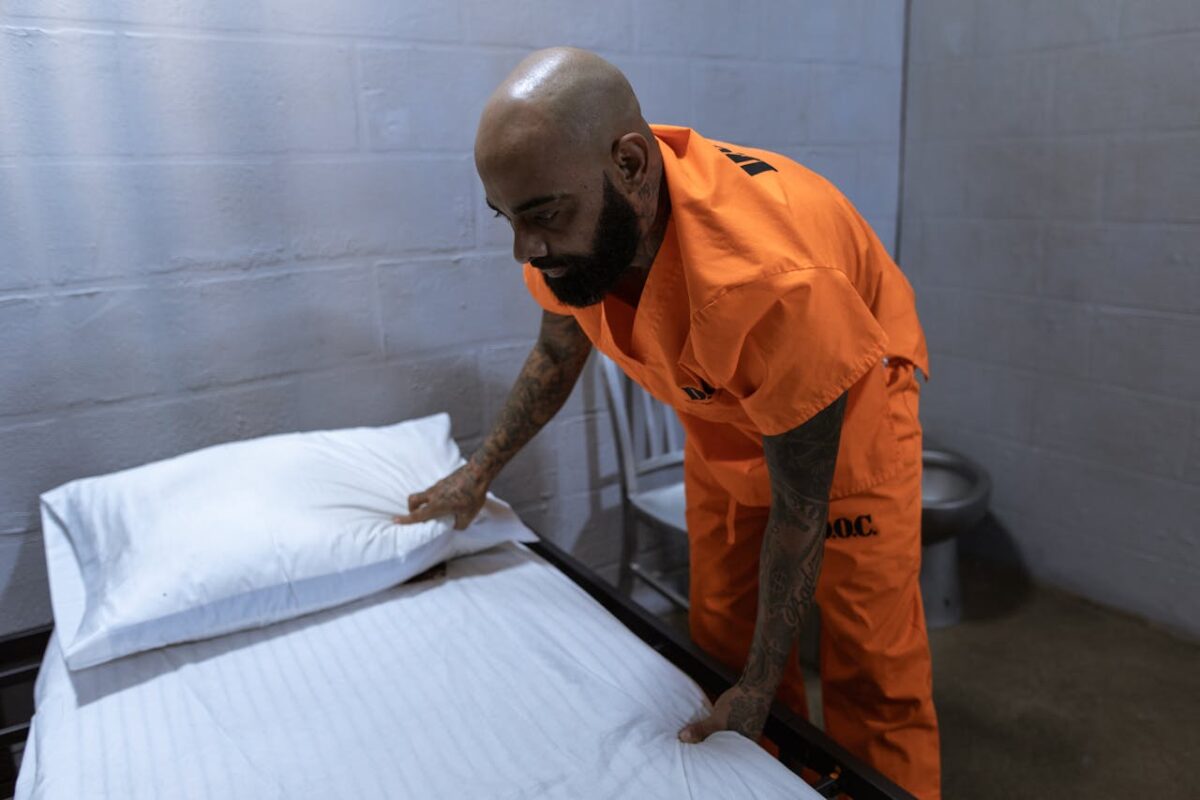 /man-in-orange-dress-shirt-and-black-pants-holding-white-textile-