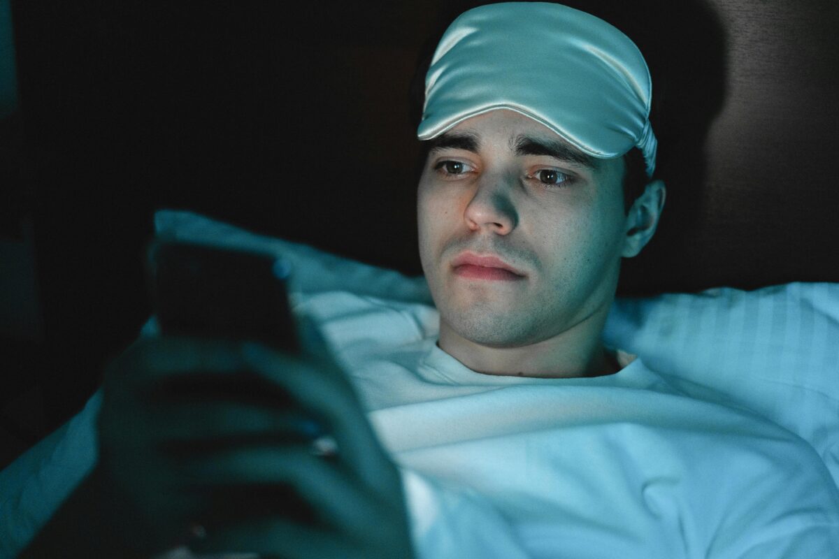 a-man-in-white-shirt-with-sleeping-mask-on-his-head