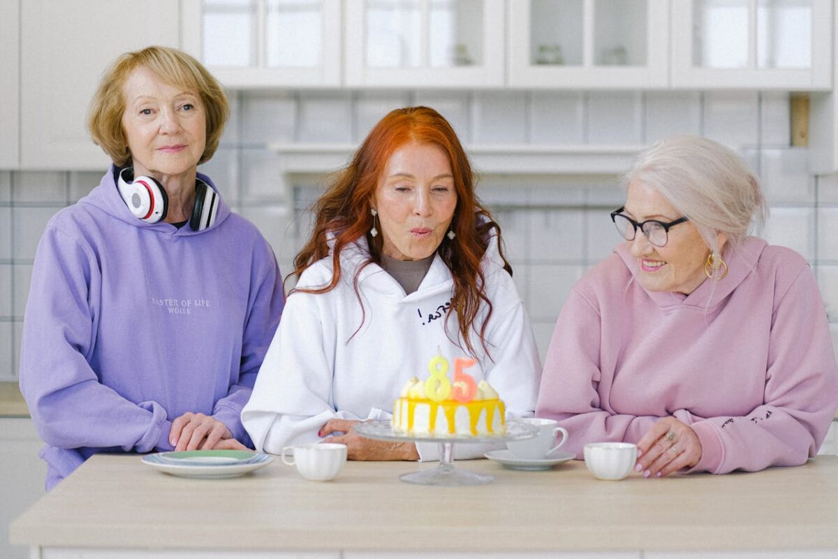 8 Reasons Calling 69 “Officially Old” Gets Aging Wrong 2 /senior-woman-blowing-out-candles-on-cake-during-celebration-birthday-with-friends-