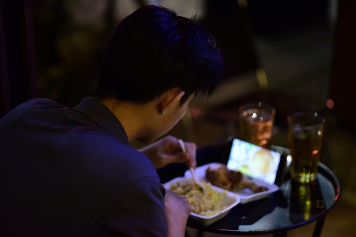 young-adult-dining-while-watching-video-on-mobile