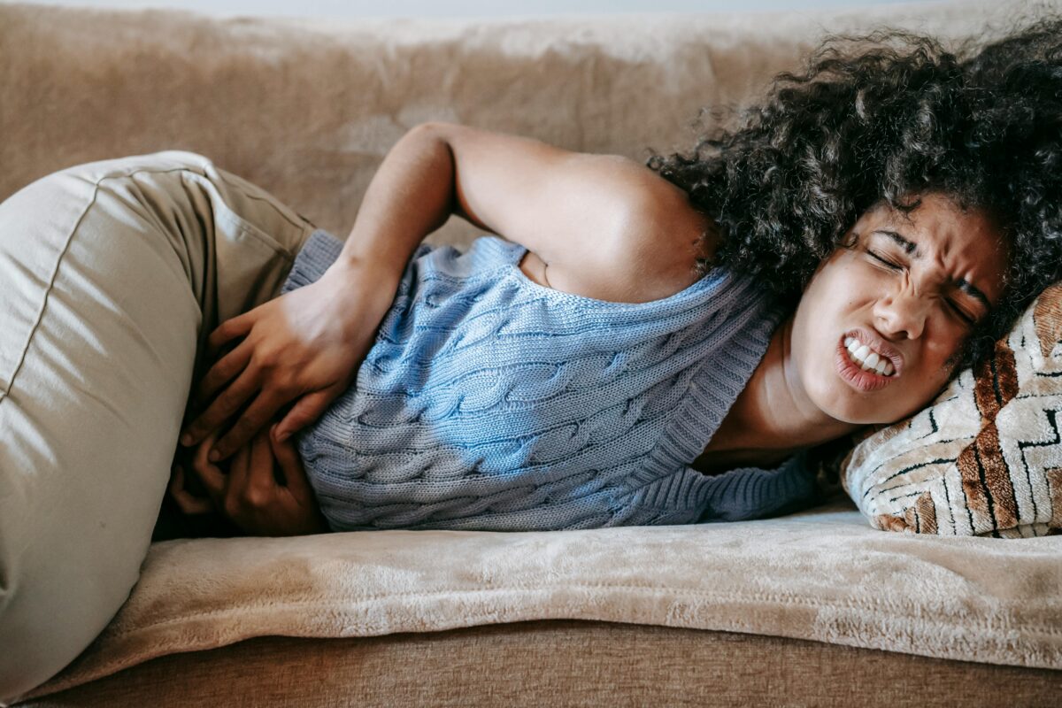 woman-suffering-from-a-stomach-pain-lying-down-on-couch