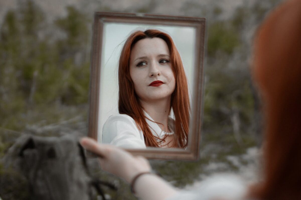 young-woman-holding-a-mirror-outside-