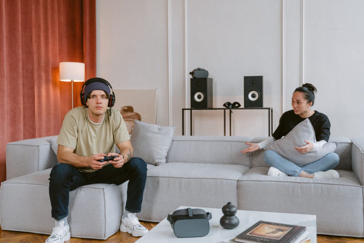 a-man-focus-playing-a-video-game-sitting-near-a-woman