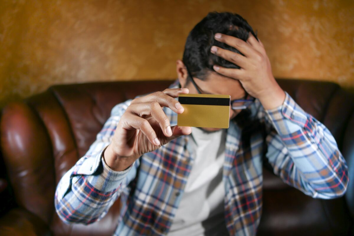 man-in-checkered-long-sleeves-shirt-holding-a-gold-card