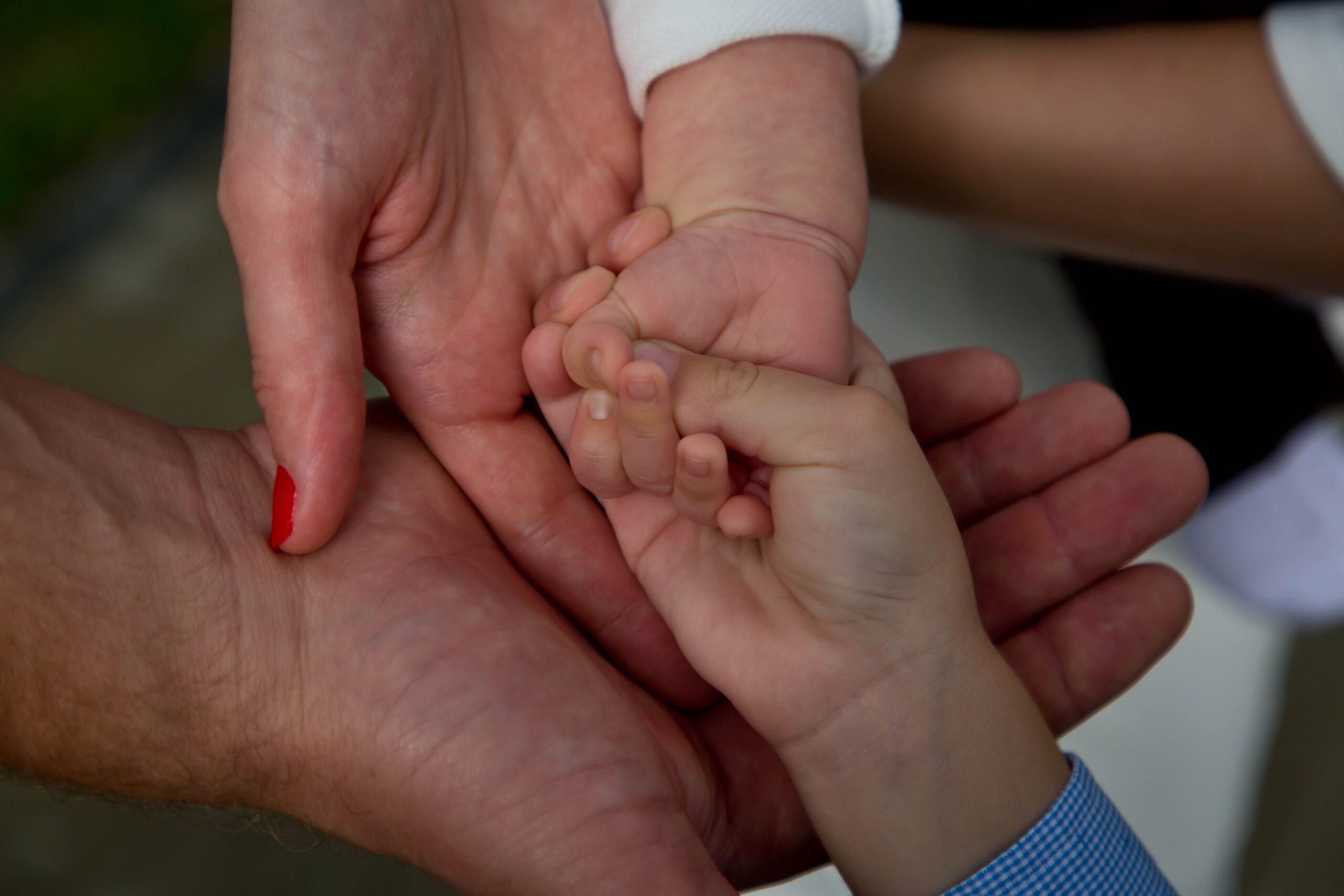 parents-holding-hand-of-their-baby