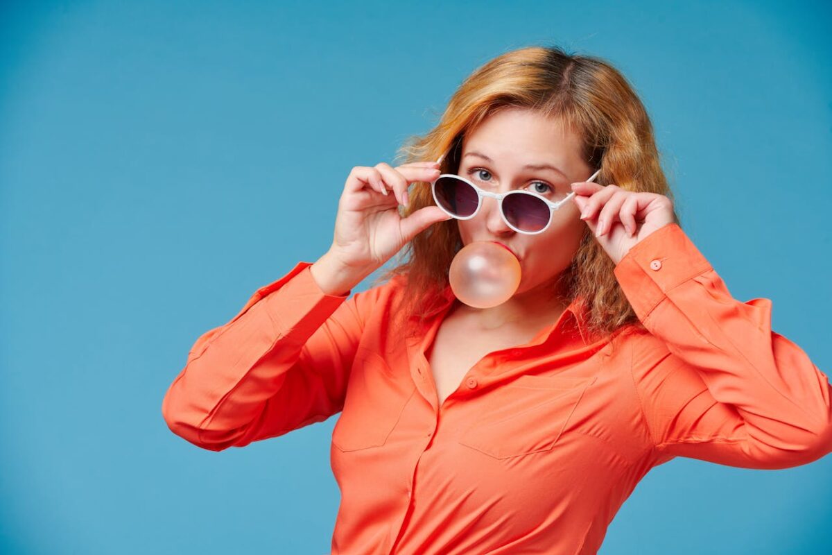 model-in-sunglasses-blowing-bubble-gum-balloon-