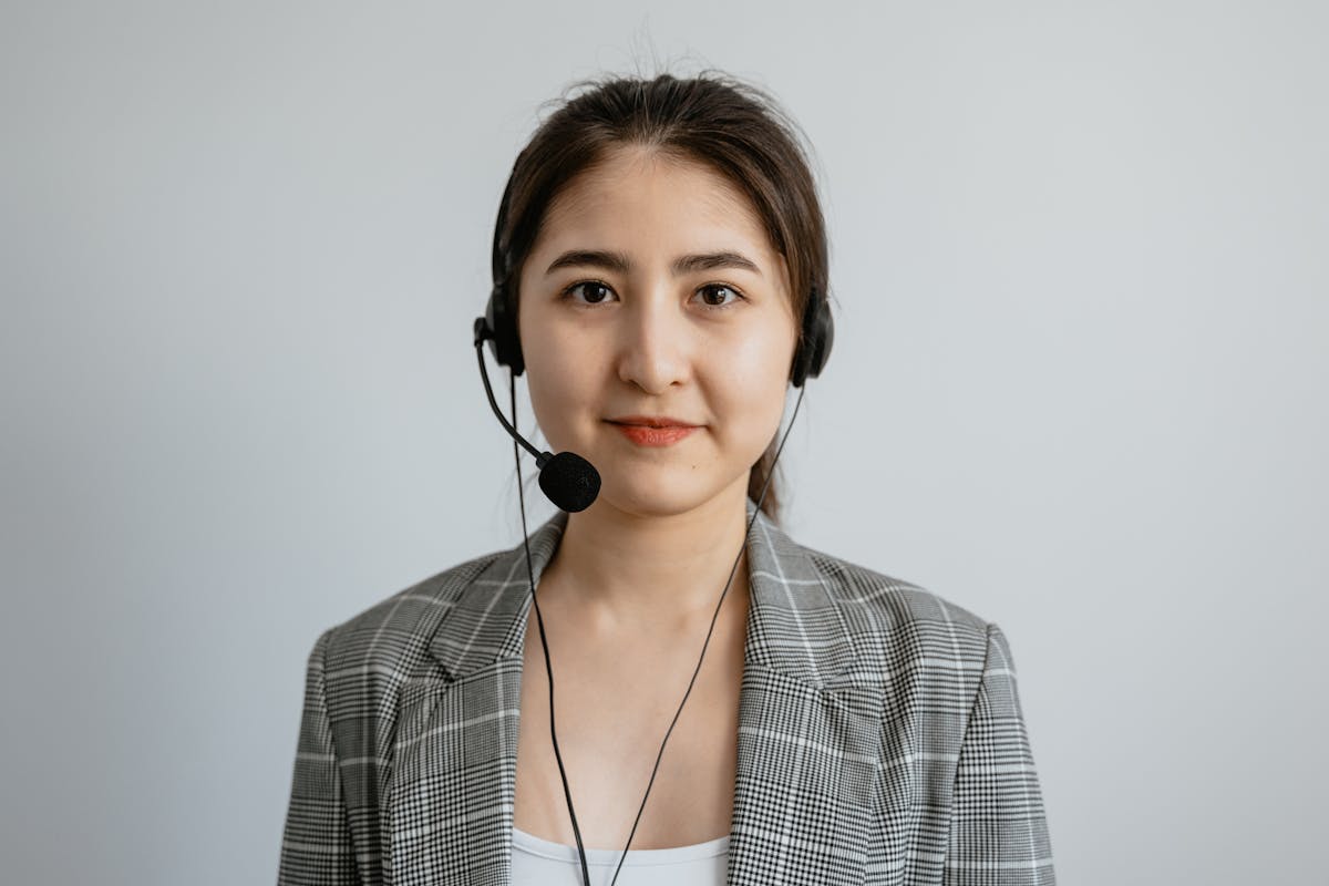 8 Jobs That Will Drain You, Age You, and Still Replace You Anyway 2 Portrait of a young female call center agent in a professional setting wearing a headset.