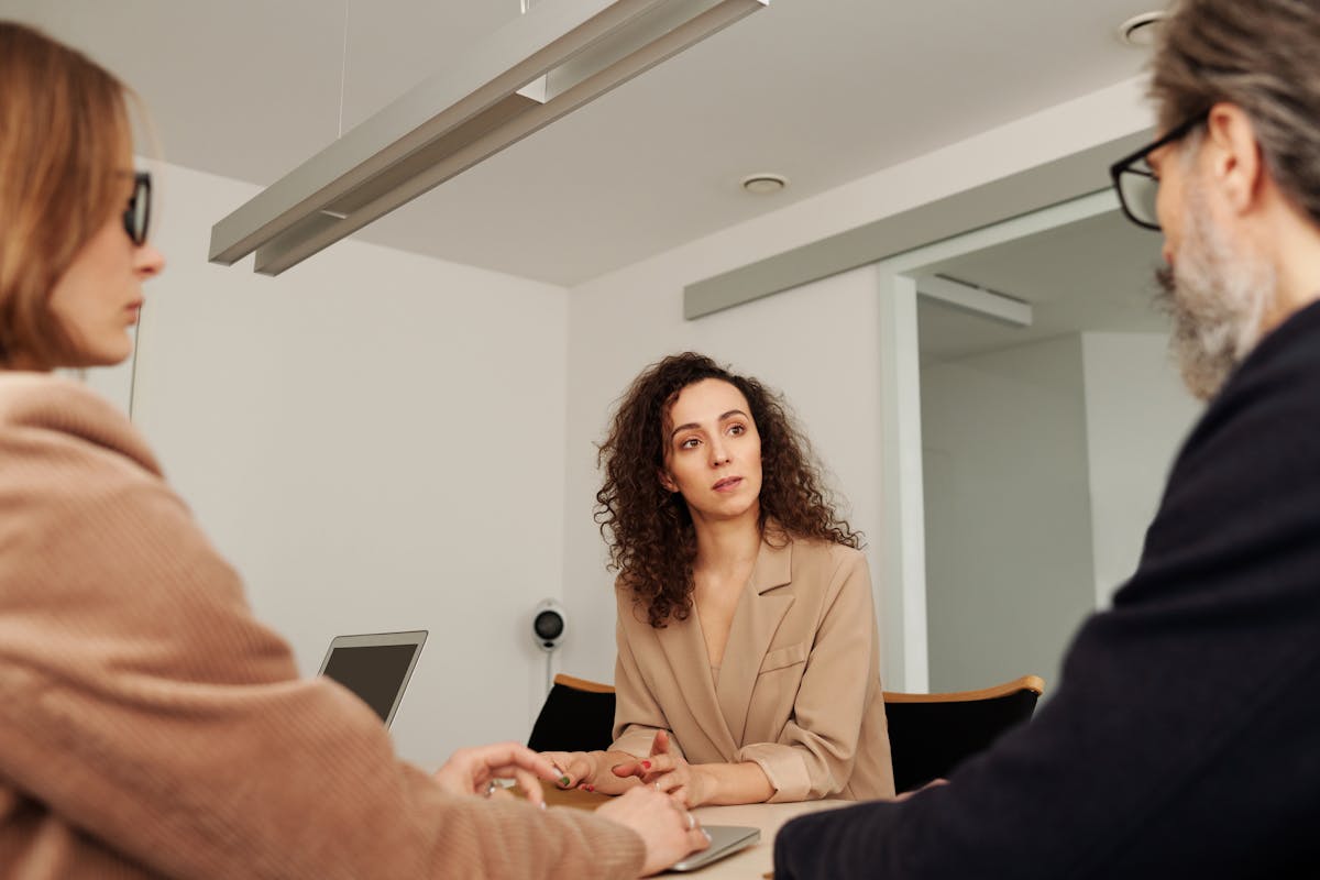 7 Indications Family Drama is Destroying Intimacy and Trust in Your Marriage 2 Professionals engage in a focused discussion during a business meeting in a modern office setting.