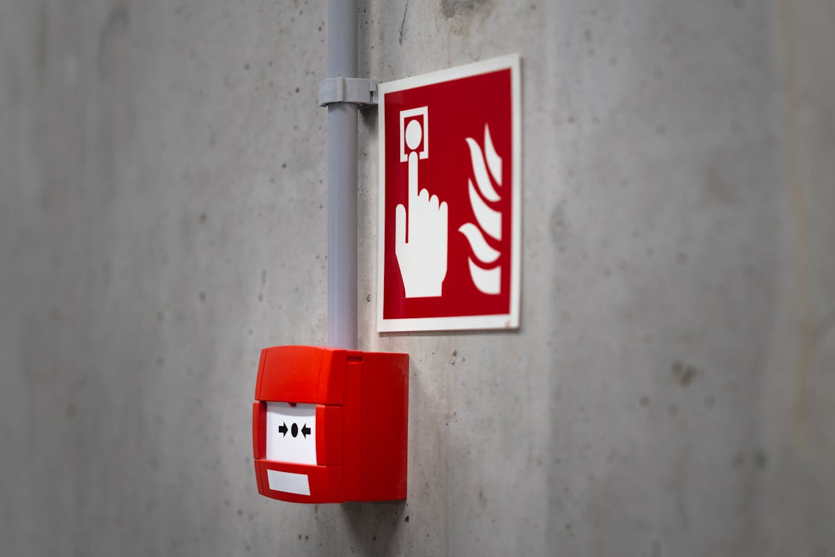 By Not Having These 12 Items ,You Are Risking Your Home’s Safety 2 Red fire alarm button and sign on a concrete wall for emergency safety indoors.