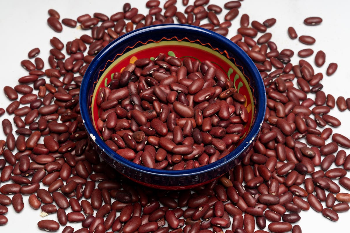 10 Everyday Foods With Hidden Risks Most People Never Think About 1 Red kidney beans in a colorful bowl surrounded by more beans. Perfect for healthy eating themes.