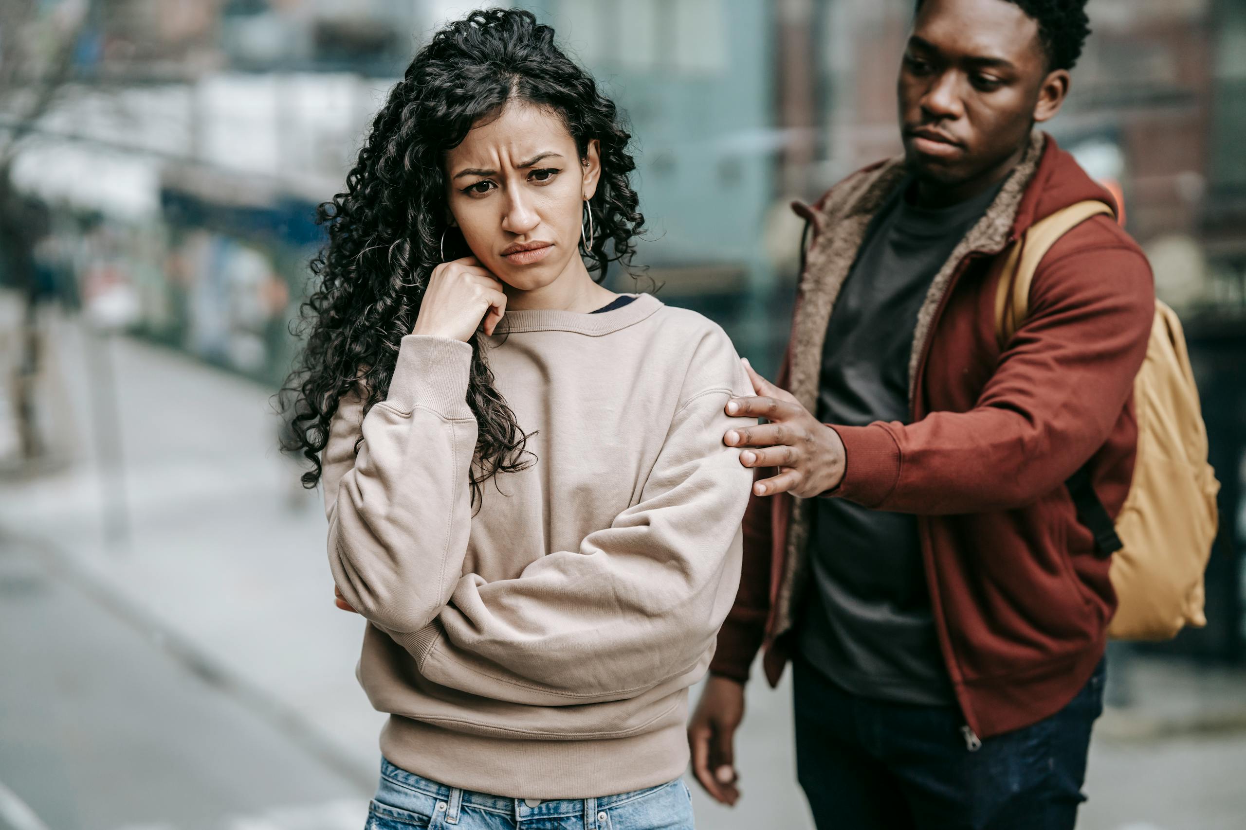 8 quiet marriage pressures that leave men exhausted before they admit it 3 Sad young multiethnic couple in casual clothes standing in city street while having disagreement in daylight