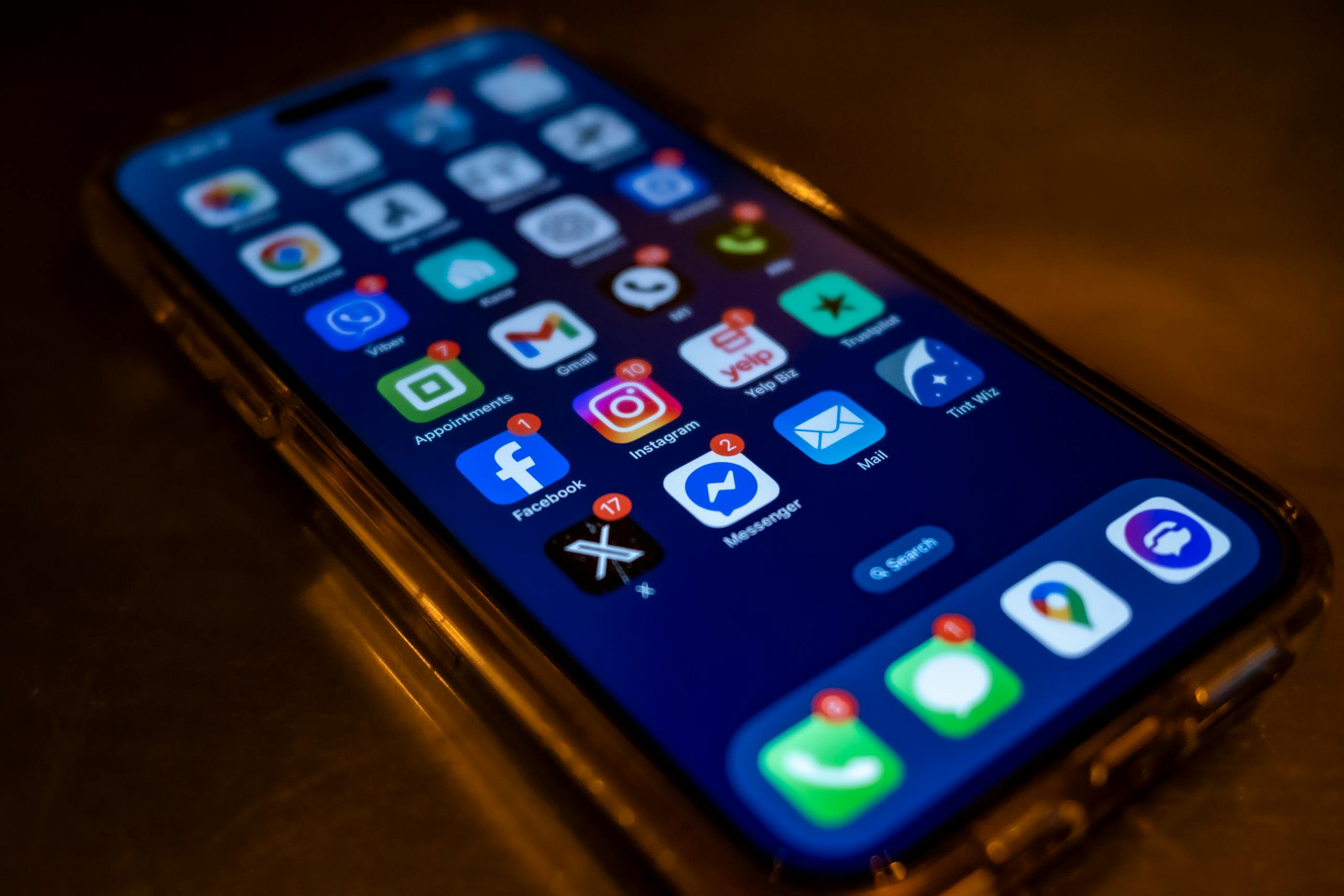 8 Ugly Reasons Social Media Is Destroying Attention Spans 2 Smartphone screen displaying social media app notifications in a dimly lit setting.
