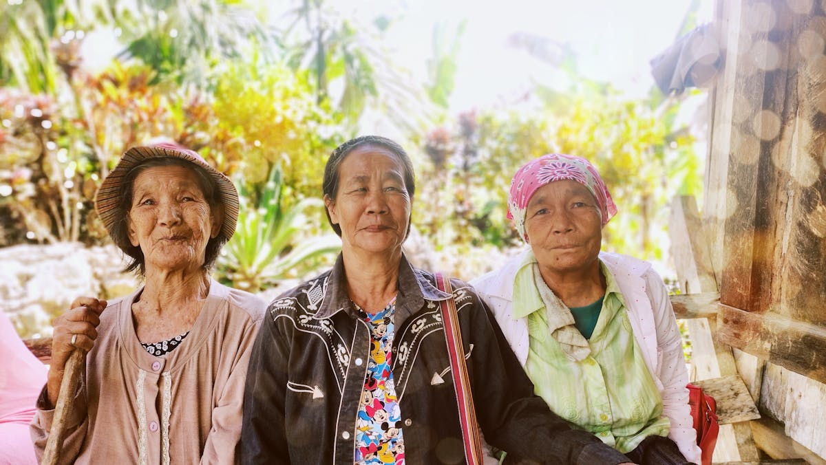 Three senior women smiling outdoors in Cordillera, Philippines.