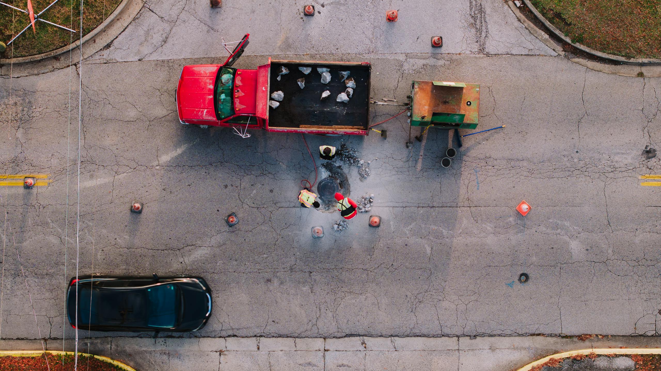 8 Disturbing Details About the Omaha Sinkhole That Swallowed Two Cars 3 Top-down view of workers doing road maintenance in Chattanooga, TN.
