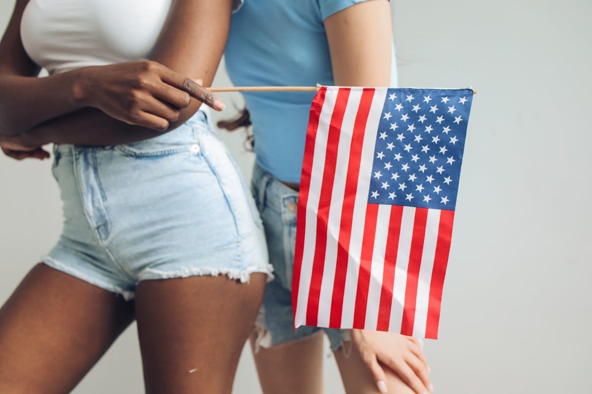8 Countries Where People Wear Their Underwear the Longest 1 Two women holding an American flag, symbolizing unity and patriotism.