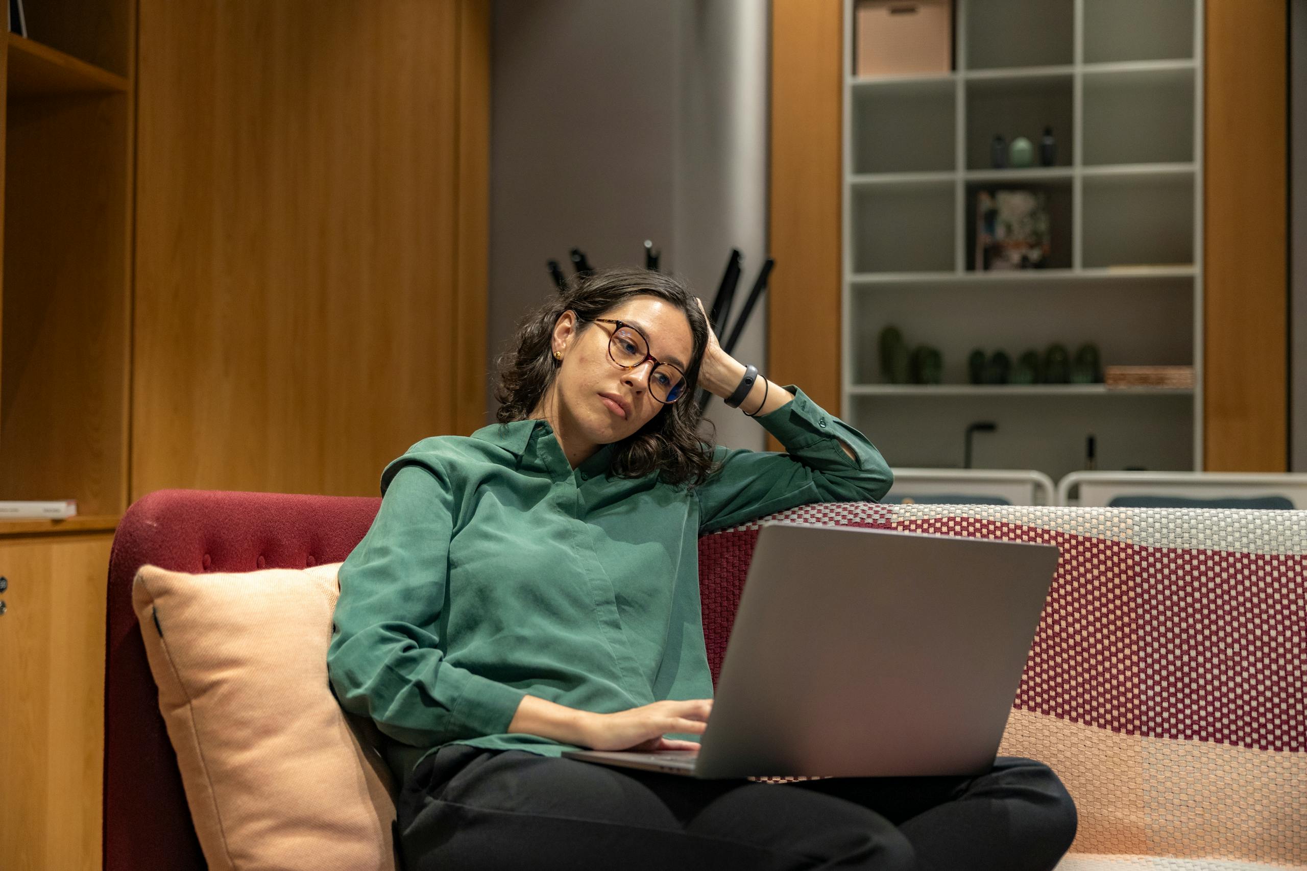 10 Disturbing Reasons Modern Friendships Are Falling Apart in America 2 Woman in a cozy workspace relaxing with a laptop, reflecting modern remote work lifestyle.