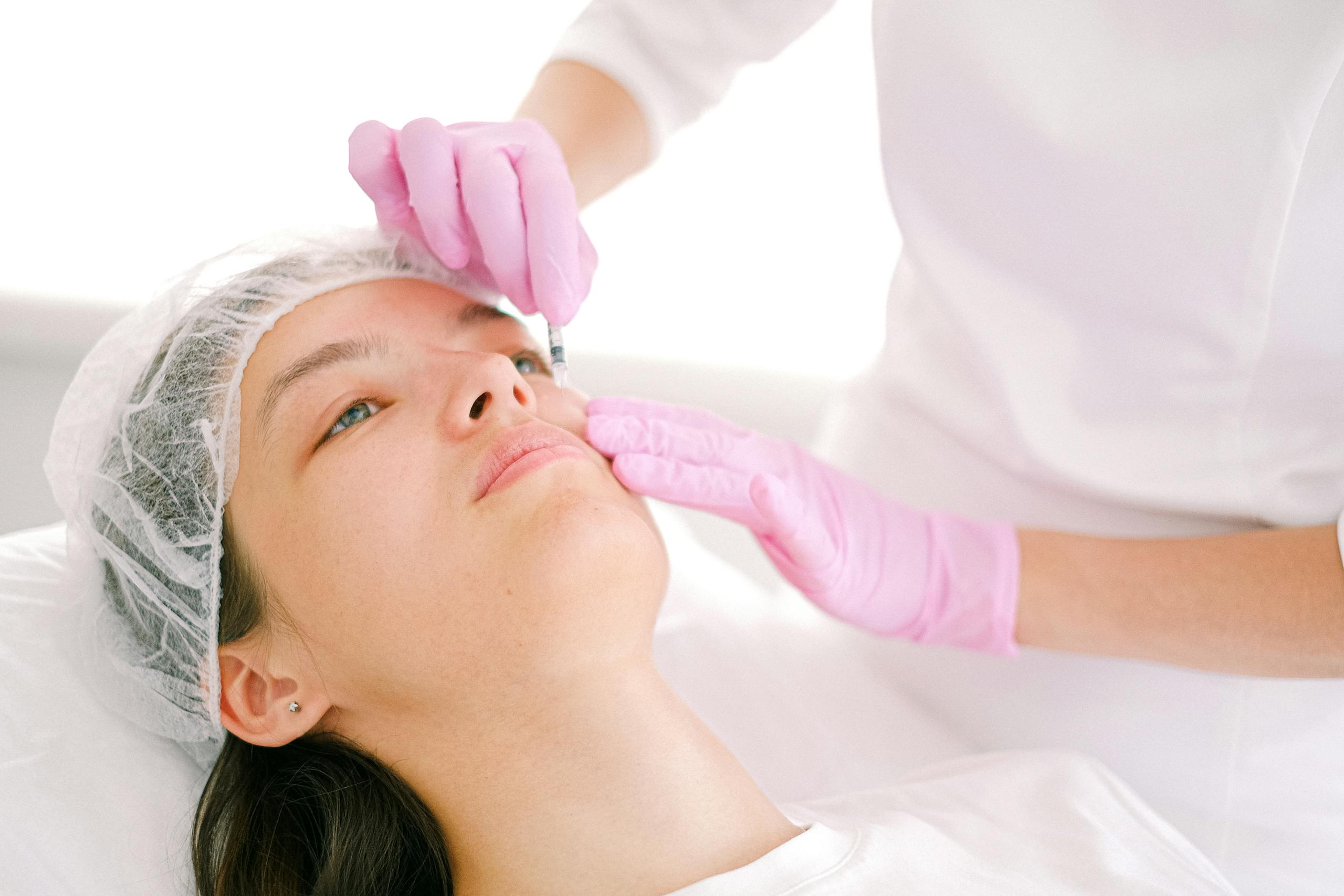 7 Reasons Botox After Pregnancy Can Become a Beauty Decision You Regret 3 Woman receives cosmetic injection in clinical setting, enhancing beauty using modern techniques.