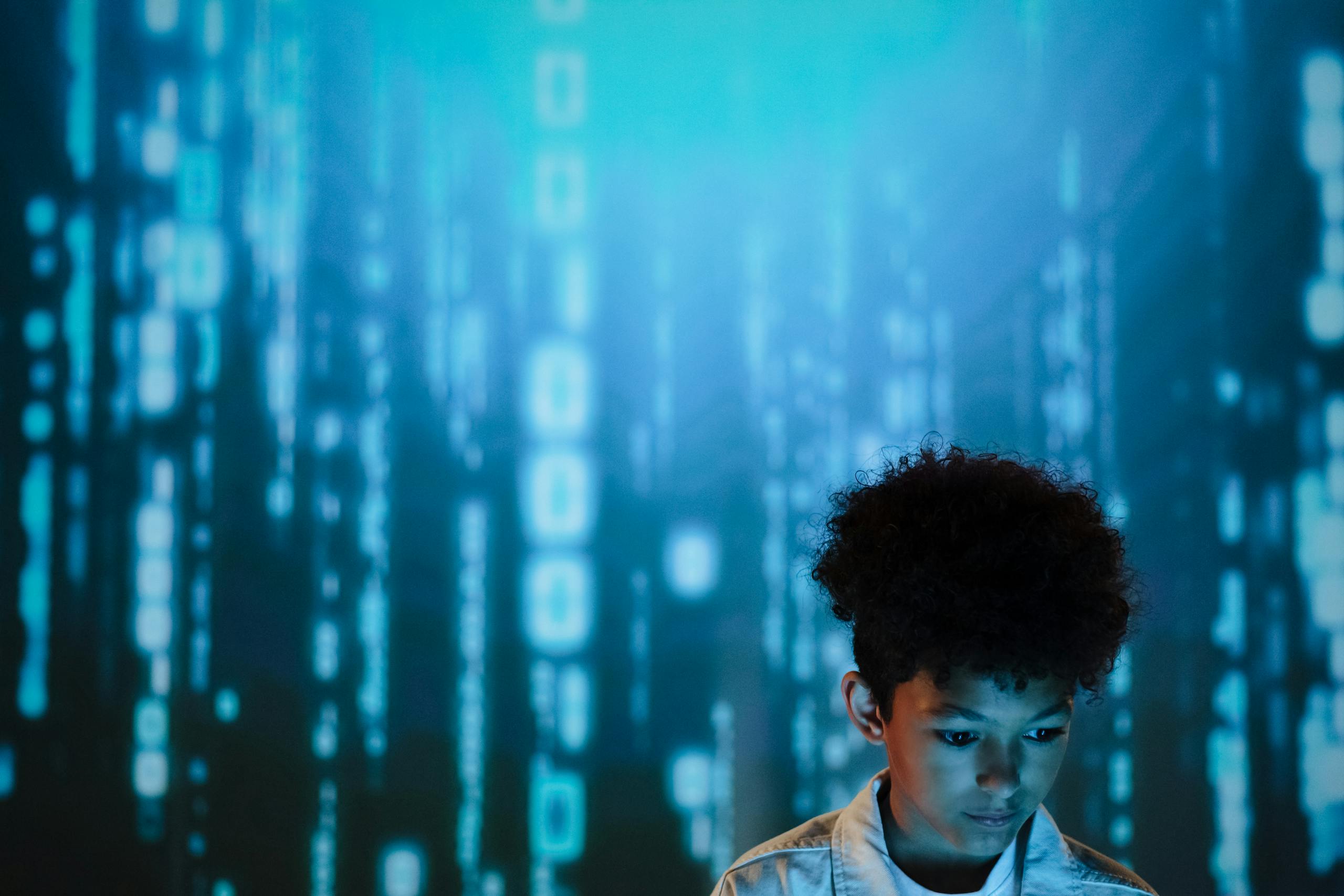 8 Creepy Ways AI Images Are Changing How People See Themselves Online 4 Young boy gazes at digital display creating a futuristic and modern atmosphere.