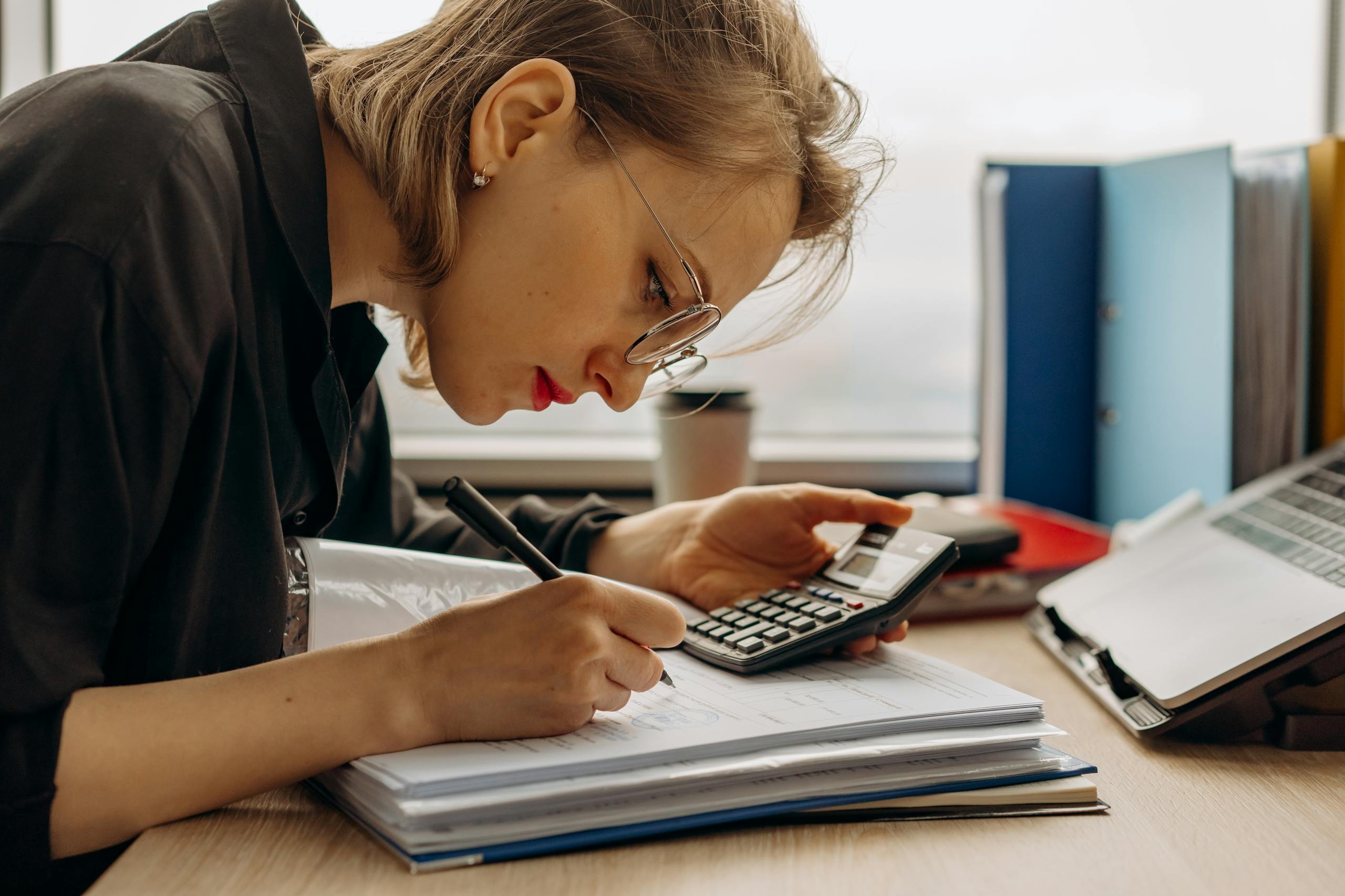 7 Types of Women Insecure Men Can’t Handle 1 Young woman diligently working on accounting with a calculator and documents. Perfect for business and finance themes.