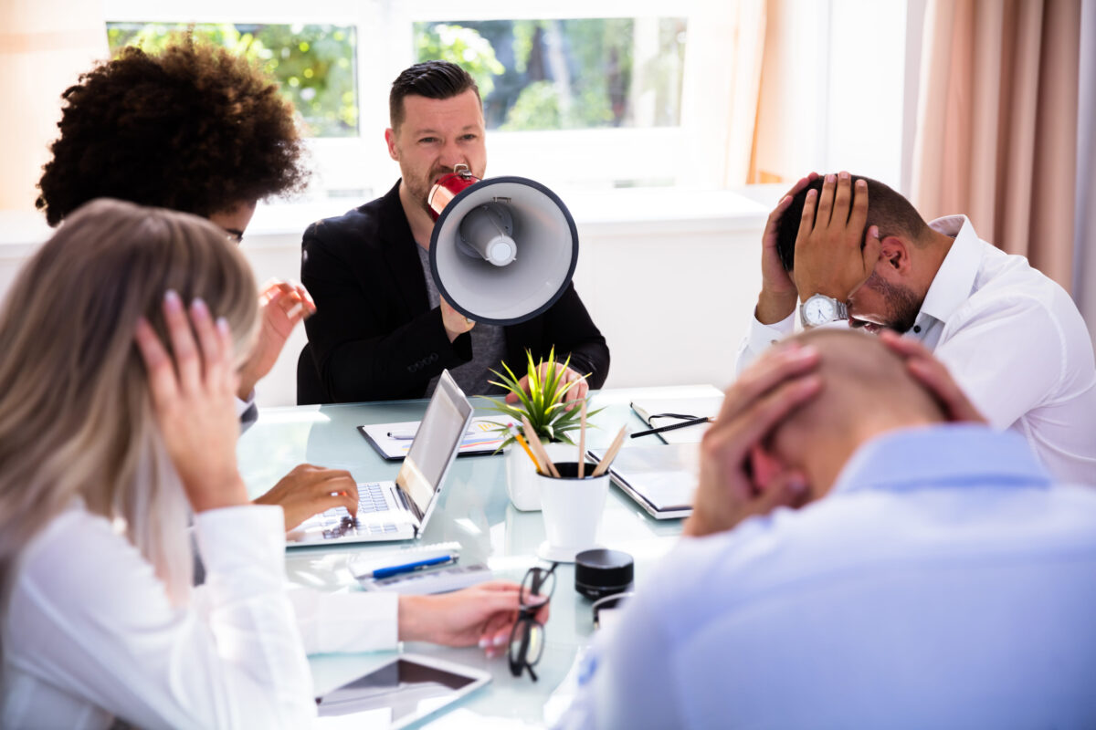 Angry Businessman Shouting At His Colleagues Through Megaphone