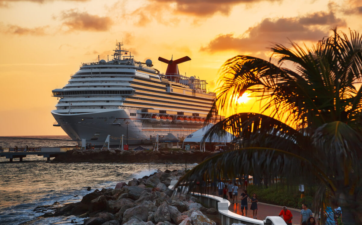 WILLEMSTAD, CURACAO - APRIL 04, 2018:  Cruise ship Carnival Conquest docked at port Willemstad on sunset.