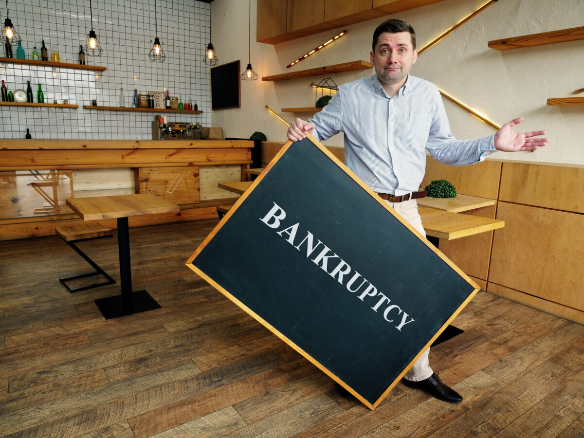 Bankruptcy. Businessman is holding blackboard.