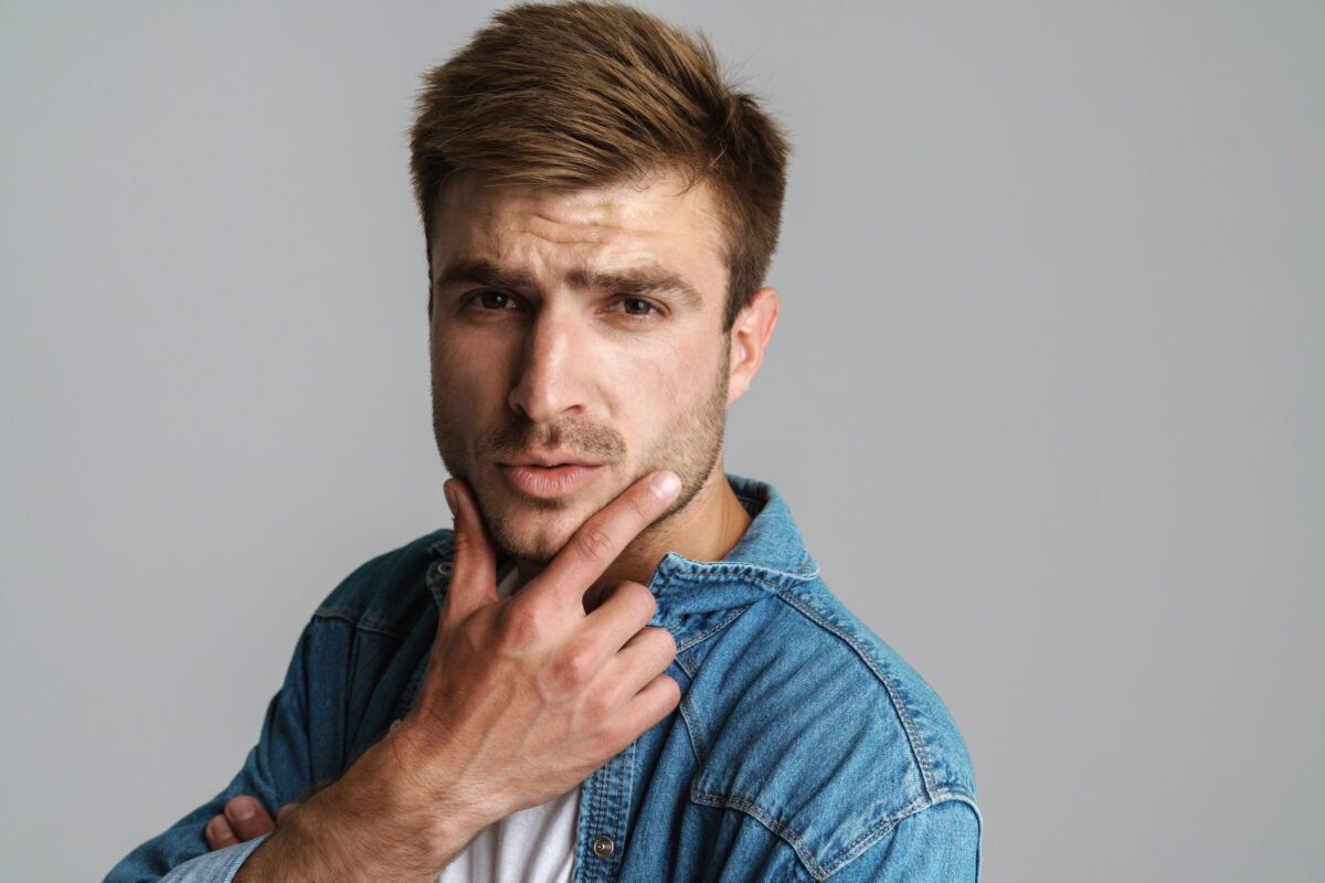 7 Harsh Rules Emotionally Unavailable Men Live By 4 Portrait of confident redhead man posing and looking at camera isolated over grey background