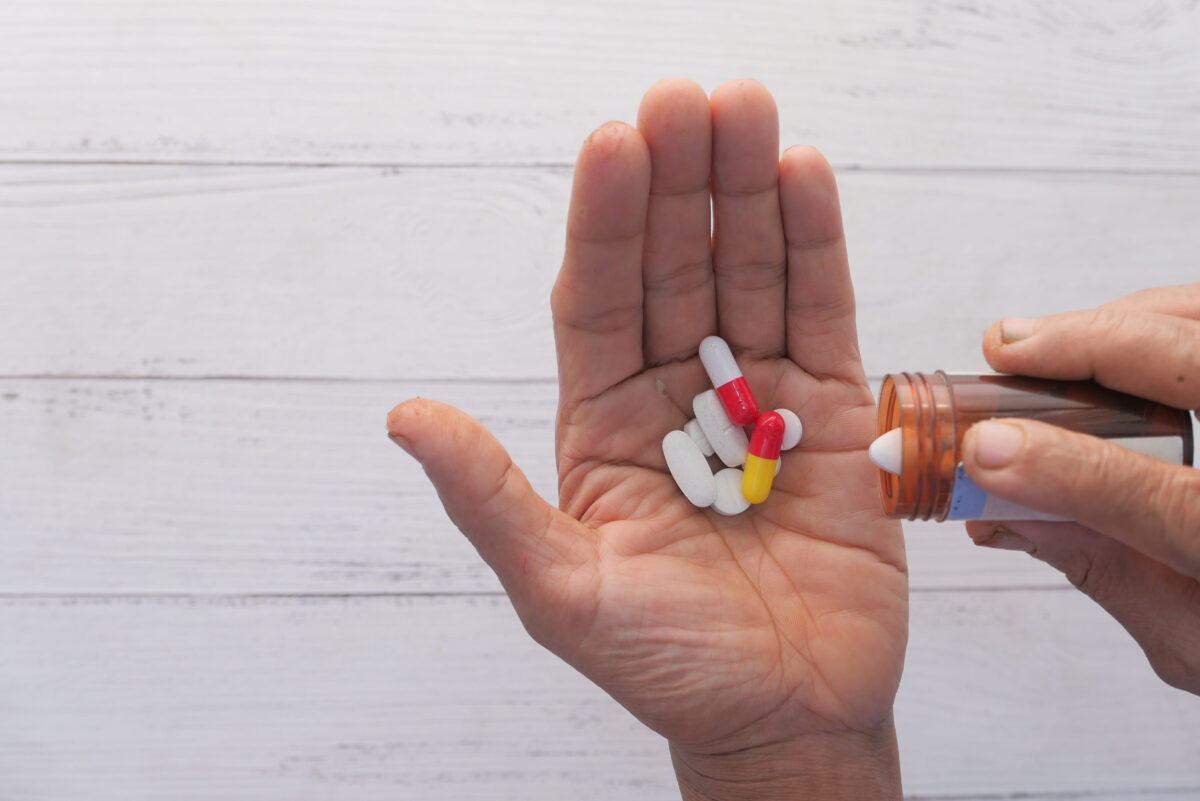 senior women hands taking medicine, close up