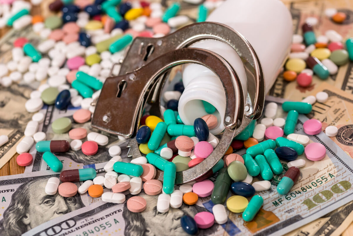 8 Dark Reasons Sex Traffickers Often Avoid Experienced Sex Workers as First Targets 3 Dispersed pills from container with handcuffs on dollar banknotes