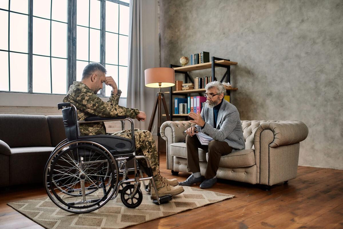 Professional psychotherapist talking to disabled man