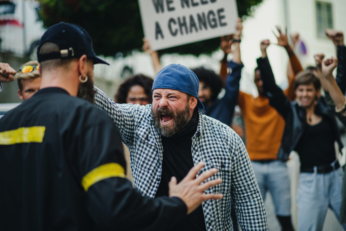 Republican Loyalty Is Starting to Crack as Voters Eye Independent Candidates, Polling Shows 2 Police stopping group of people activists with raised fists protesting on streets, BLM demonstration concept.