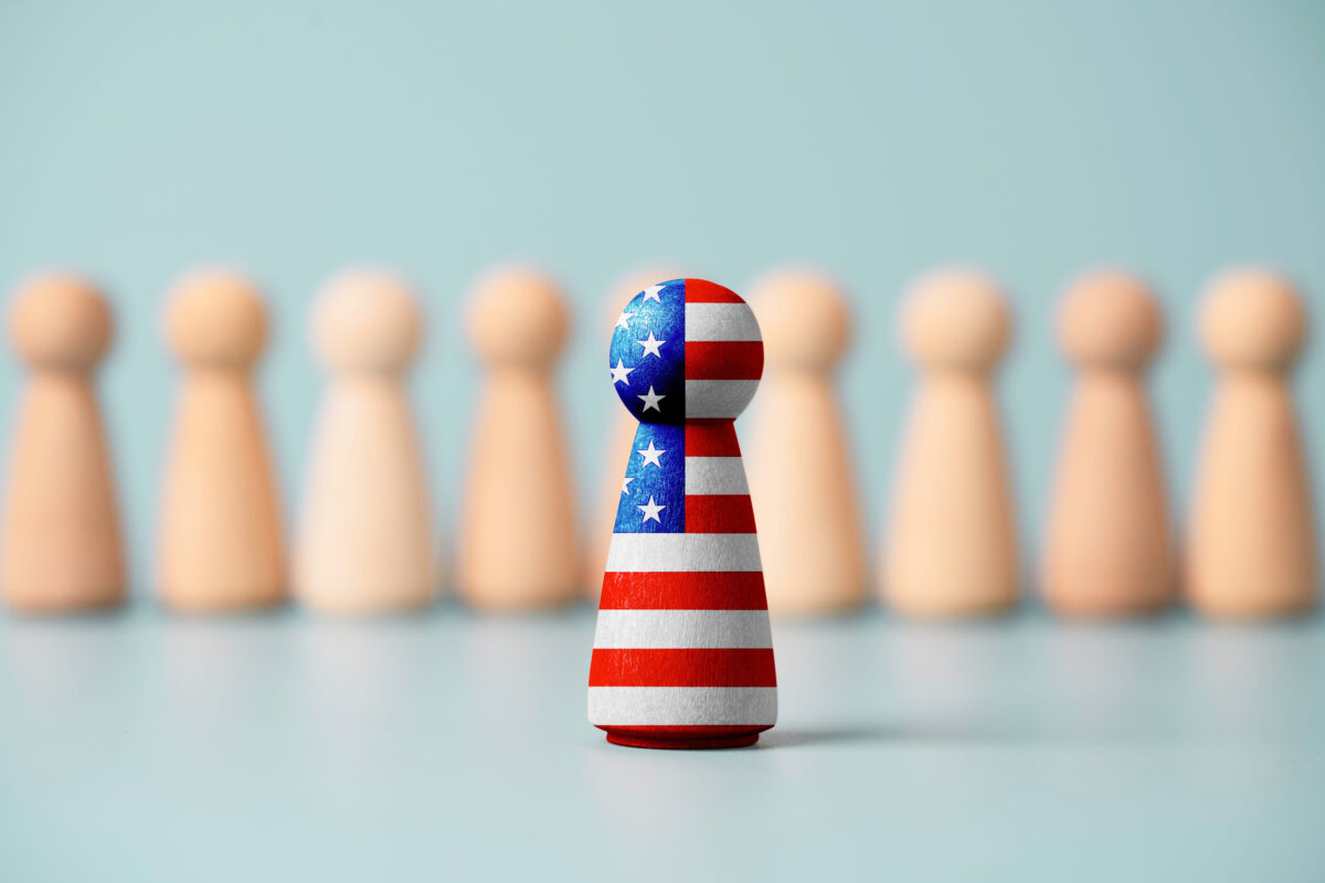 USA flag print screen on wooden figure and standing in front of others figure , United States country is leader in business , technology and military in the world.
