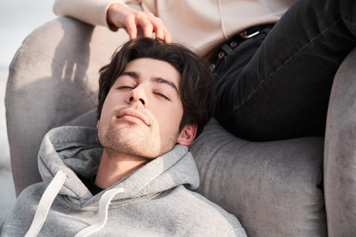 7 Worst Signs of a Weak Man Women Secretly Hate 4 Man laying with his head at armchair and enjoying of touching of his wife