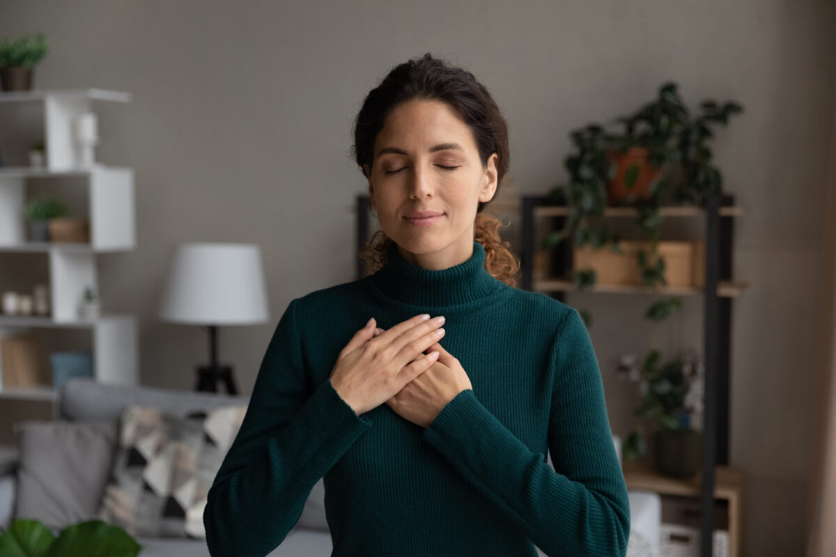 7 Ways to Break Free from the Pressure to Be a Perfect Christian 3 Blissful minute. Peaceful young latin female stand alone keep eyes closed put hands on heart pray thank god for kind wonderful things in life. Sincere lady feel grateful to fate for every good moment