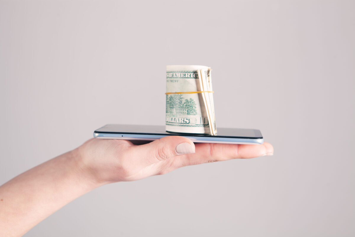 The Psychology Behind Digital Tipping: Tap-to-Tip Screens Are Changing Guest Behavior 2 girl holding a phone and money