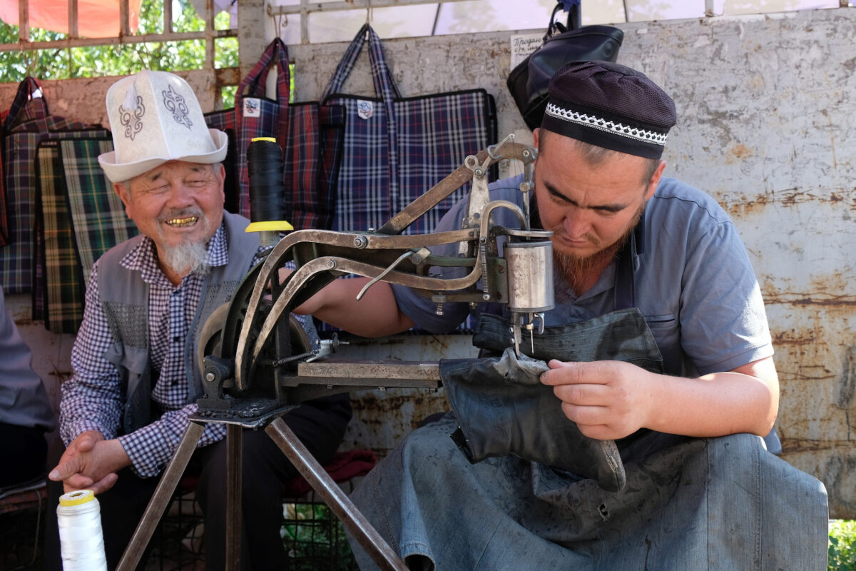 10 Things Older Generations Did Better Than Us 2 Bishkek, Kyrgyzstan - circa July 2022: A Kyrgyz shoemaker at work in the Osh bazaar in Bishkek.
