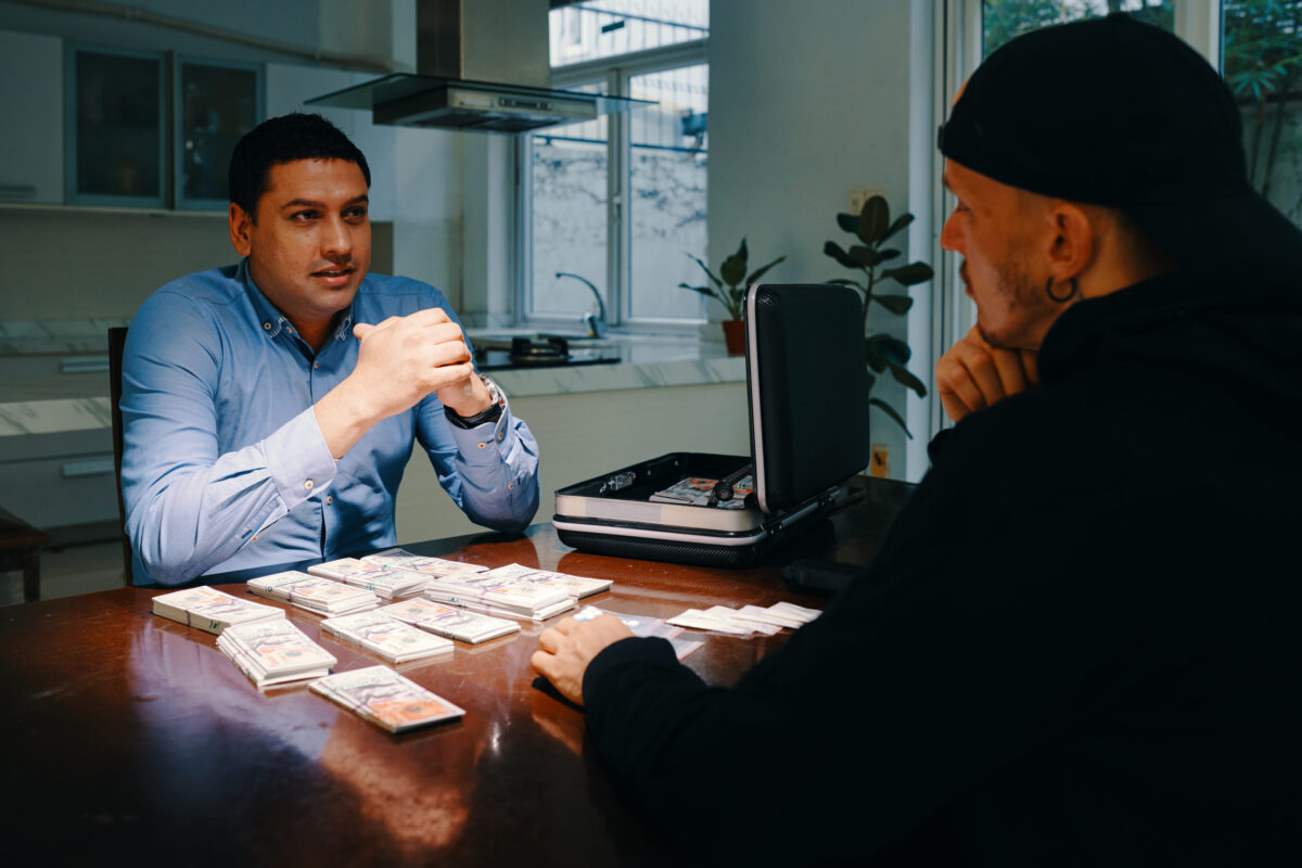 Customer offering drug dealer money for some doses when they are sitting at kitchen table